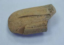 أدوات فخار ملونه بالأسود إلى جانب مسكه لقارورة عليها ختم باللغة اليونانية