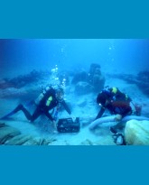 Divers excavating with a dredging system