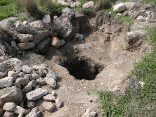 פתח הכניסה למקווה, שנחשף במהלך חפירת השוד. מסביב - שפך האדמה וההרס